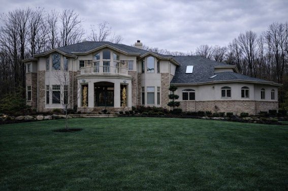 Sovereign Oaks, a stone and stucco estate home with a second-floor balcony