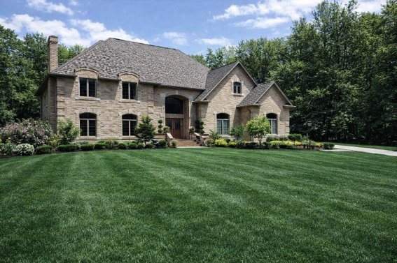 A stone two-story custom home with an arched entry built by Sudon Brothers